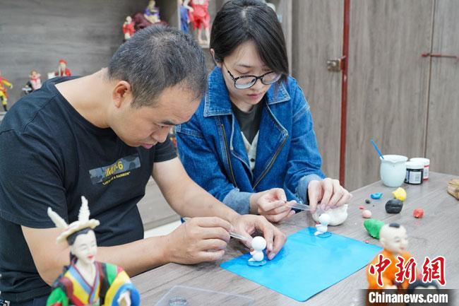 <a target='_blank'  data-cke-saved- >中新社</a>記者(右)現(xiàn)場體驗面塑制作過程?！￡悹帍?qiáng) 攝