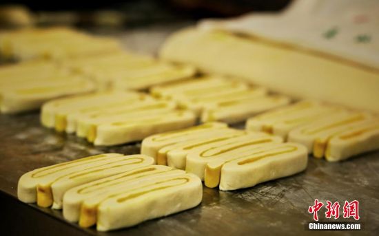 圖為面劑被涂上胡麻油，切成條狀用作月餅的花型制作。張文 攝