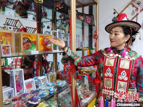圖為身著民族服飾的隴原巧手展示手工藝品。(資料圖) 徐雪 攝