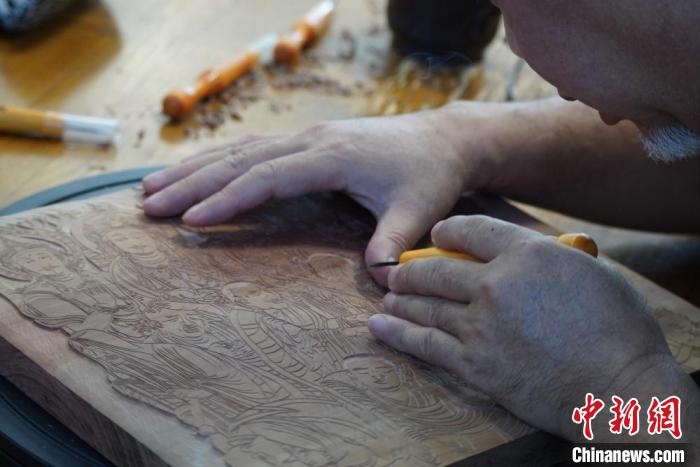 圖為徐晉林湊近木板，近距離制作雕版畫?！【琶赖┰?　攝