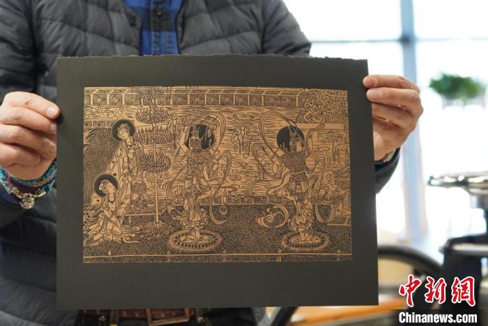 圖為手工書藝人展示敦煌雕版壁畫印刷品?！【琶赖┰?　攝
