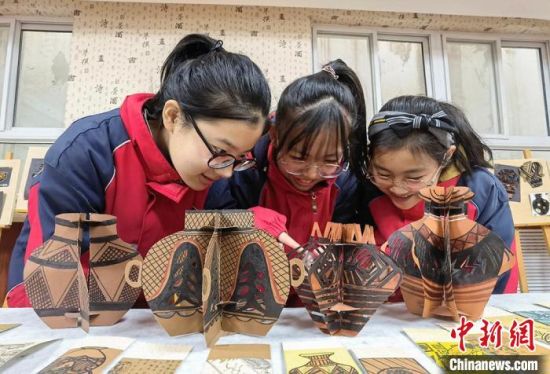 圖為學(xué)生用紙創(chuàng)作的立體彩陶?！⒂裉?攝