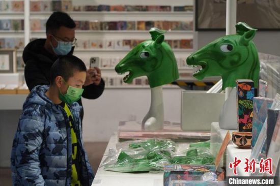 圖為“神馬來了”銅奔馬頭套吸引參觀者駐足?！【琶赖┰?攝