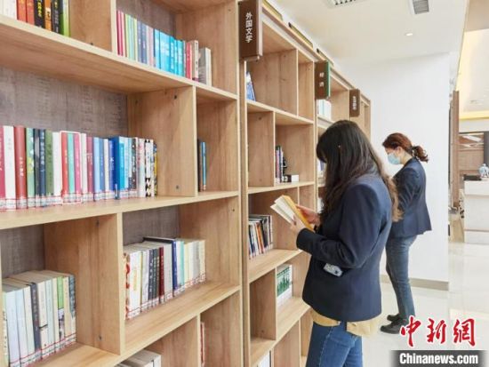 圖為在甘肅公航旅建設(shè)集團(tuán)有限公司的職工書屋，職工挑選書籍。　徐雪 攝