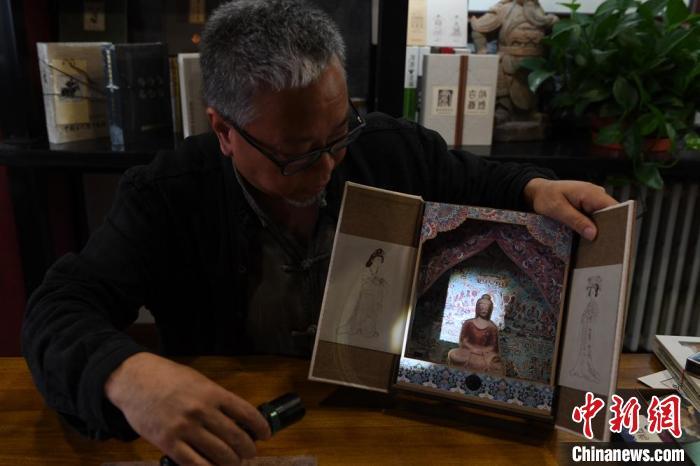 圖為讀者出版集團(tuán)讀者晉林工作室獨立出品人徐晉林，展示互動性強(qiáng)的敦煌題材手工書。(資料圖) 楊艷敏 攝