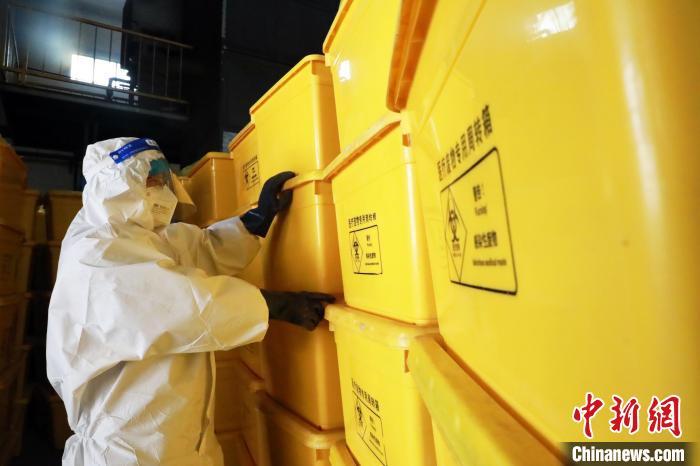 圖為工作人員搬運(yùn)醫(yī)療廢物專用周轉(zhuǎn)箱?！∥航ㄜ?攝