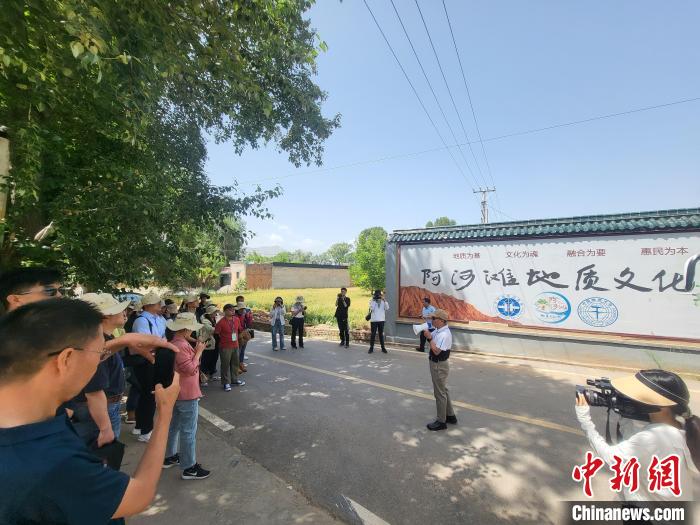 圖為中國地質(zhì)大學(北京)教授張緒教介紹村落情況。　胡友軍 攝