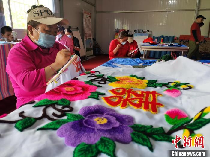 圖為婦女制作青繡?！?zhí)砀?攝