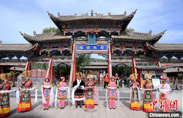 圖為身穿土族服飾的工作人員迎接訪客?！⊙Φ?攝