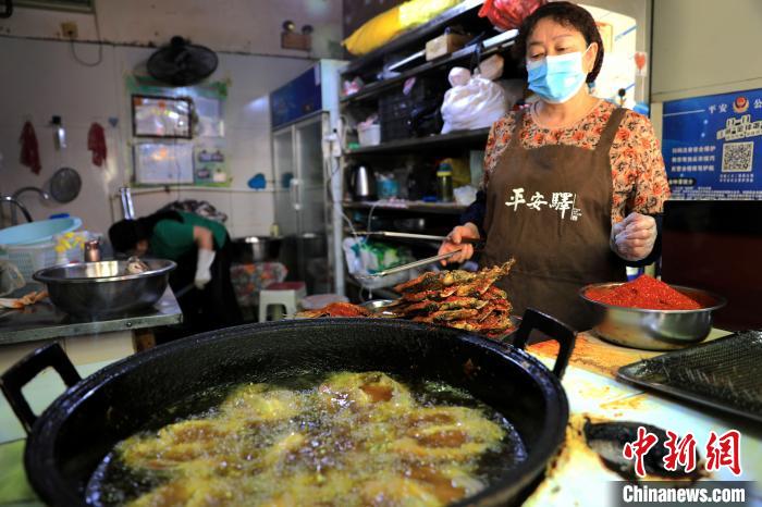圖為平安驛·河湟民俗文化體驗地內的商戶炸干板魚。　薛蒂 攝