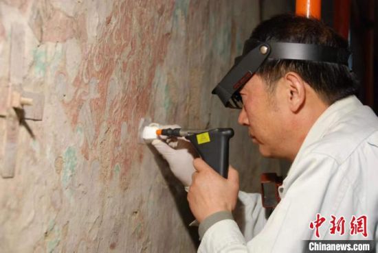 敦煌研究院研究員樊再軒進行壁畫修復(fù)。(資料圖)張云文 攝