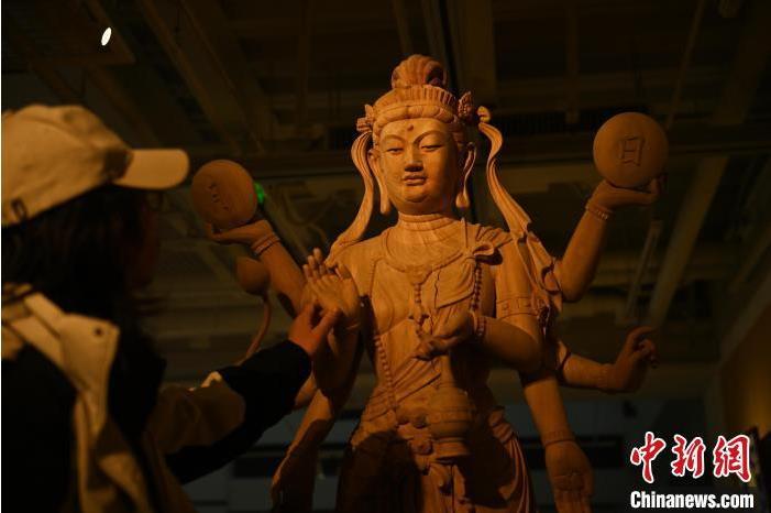 圖為季茂杰觀察自己創(chuàng)作的敦煌木雕。李亞龍 攝</p>
<p>