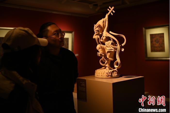 圖為季茂杰向參觀者介紹自己創(chuàng)作敦煌木雕的過程。李亞龍 攝</p>
<p>