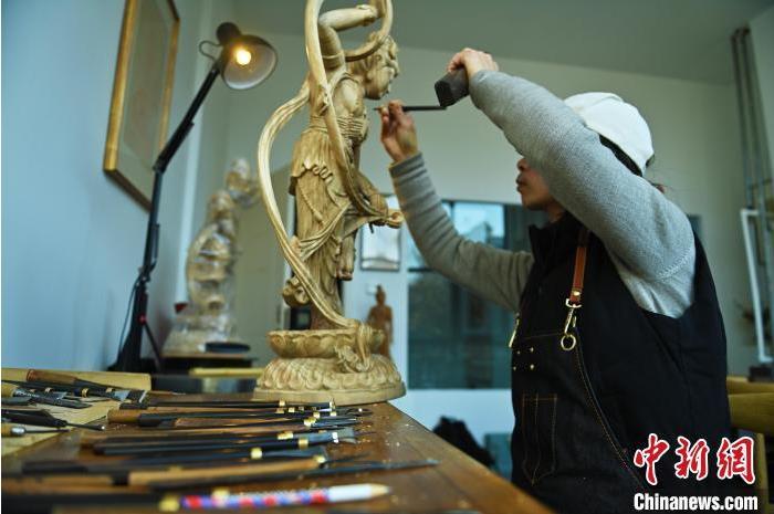 圖為季茂杰進(jìn)行敦煌元素的木雕創(chuàng)作。李亞龍 攝</p>
<p>