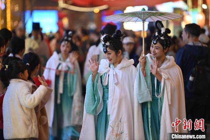 圖為街區(qū)人員著傳統(tǒng)服飾與游人互動。李亞龍 攝</p><p>