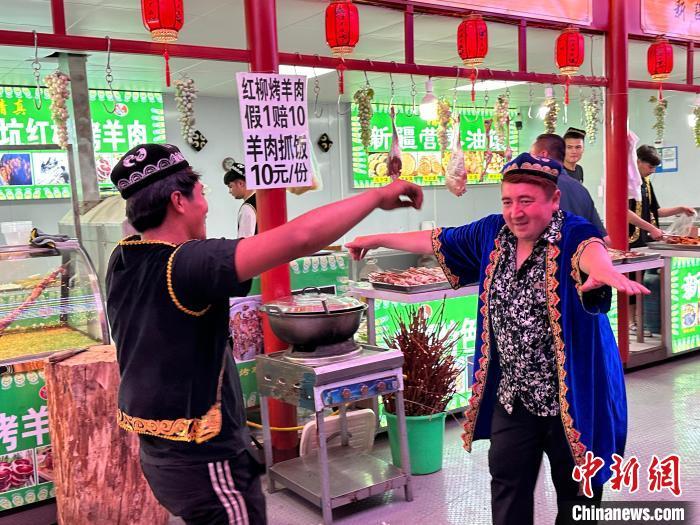 圖為餐飲經(jīng)營者在“西涼不夜城”跳起舞蹈引客。　戴文昌 攝</p><p>