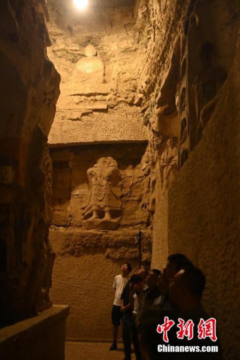 7月15日，游人參觀甘肅省平涼市涇川縣百里石窟長廊中的王母宮石窟。百里石窟長廊位于涇川縣境內，由512個石窟、5眼窟中石井組成，現(xiàn)存王母宮石窟、鳳凰山石窟、南石窟寺、丈八寺石窟、羅漢洞石窟、太山寺石窟等規(guī)模較大的石窟群，還有數(shù)量眾多的小石窟群。王母宮石窟又名千佛洞，該窟設計宏大，造像生動，窟內擁有造像數(shù)百尊，是較為珍貴的佛教文化遺存。中新社記者 李亞龍 攝</p>
<p>
