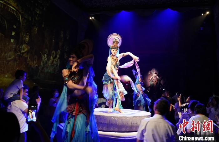 《樂動(dòng)敦煌》是全球首部洞窟式沉浸體驗(yàn)劇，利用真人與數(shù)字影像虛實(shí)交換實(shí)現(xiàn)沉浸式體驗(yàn)。圖為2023年8月28日晚，《樂動(dòng)敦煌》演出。(資料圖)中新社記者 毛建軍 攝