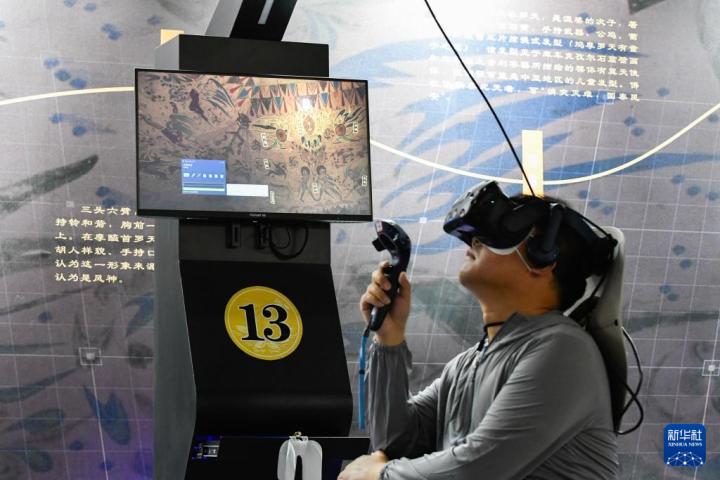 7月22日，游客借助VR設(shè)備沉浸式游覽莫高窟第285窟虛擬場景。新華社記者 郎兵兵 攝